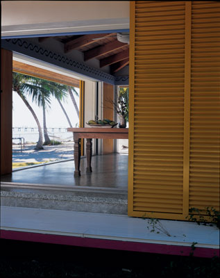 
Bright yellow shutters form the outermost layer of hurricane protection for the living/dining room. The panels slide to the sides along with the glass doors, opening wide to expose the living room almost completely to the outdoors. 'Sometimes, when a squall comes up, we feel like we're living on a boat,' says Ron.
